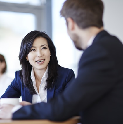 Asian woman looking at her coworker