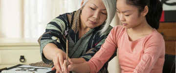 Grandmother helping young granddaughter with homework at home